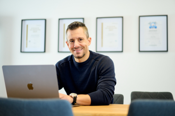 Oliver Pfeil am Schreibtisch mit Laptop